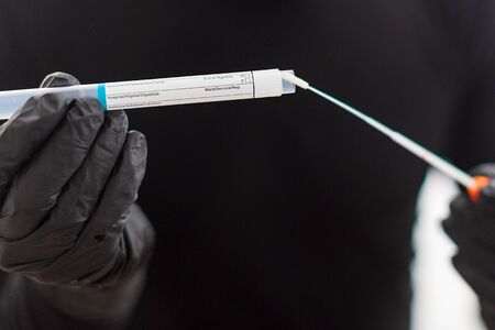 Corona virus Covid-19 respiratory sputum specimen swab test tube with glovesの写真素材