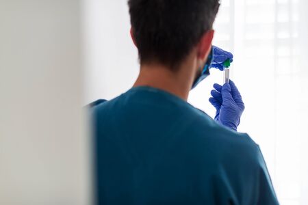 medical or scientific researcher or doctor looking at a test tube in a laboratoryの写真素材