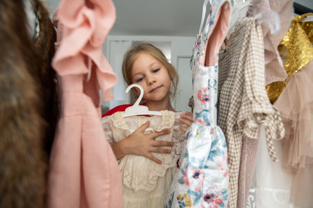 Cute little girl choosing clothes in dressing roomの写真素材