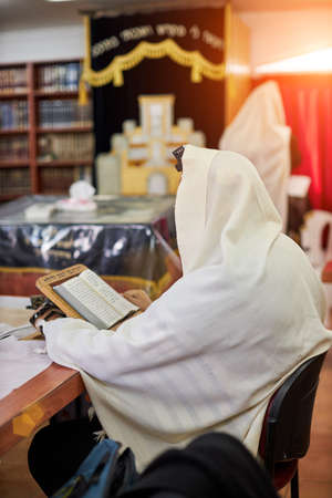 Orthodox ultra Orthodox Jew from a tallit in the synagogue. rear view of an orthodox Jew in the mantle, a bit in the synagogueの写真素材