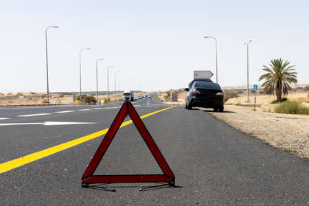 car with a breakdown alongside the road in the desertの写真素材
