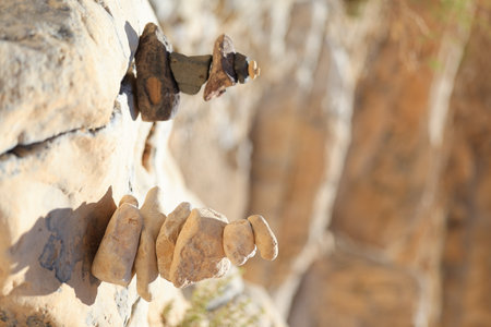 Pyramid stones balance on the sand rock. The object is in focus, the background is blurredの写真素材