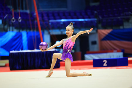 Rhythmic gymnastics in the professional arena. Performance with the ball in front of the audienceの写真素材