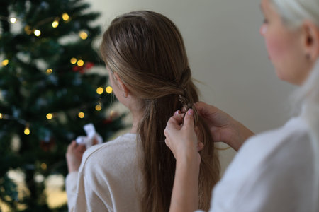 mother and daughter decorate the christmas tree