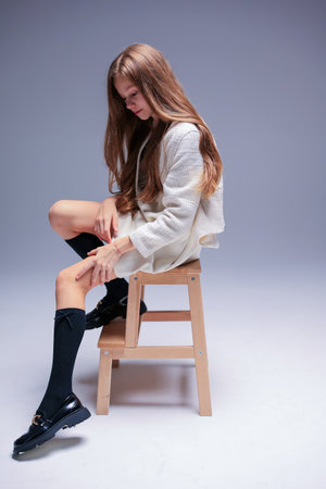 An Impressive and Stylish Portrait Featuring a Model on a Stool Set in a Minimalist Environmentの写真素材