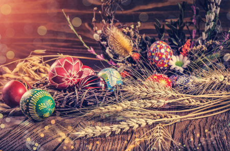 Easter background. colored Easter eggs in the nest, composition of dried flowers, plants and ears of wheat. on wooden background. Easter theme. Happy Easter. inctagram toning ahd soft light effectの写真素材