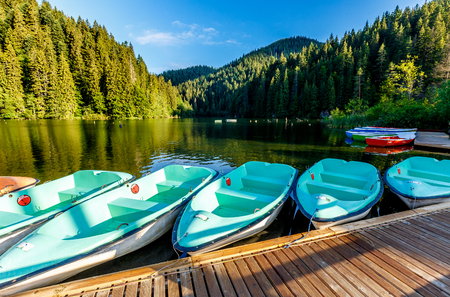 Wonderful summer morning. majestic mountain lake Lacul Rosu in mountain. boats under sunlight. unusual sunny landscape. Lacul Rosu the Red Lake or Killer Lake. location. Evrope. Eastern Carpathian. Romania.  filterの写真素材