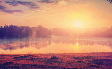 Magnificent sunny landscape. foggy lake with colorful sky, shining with sunlight. Creative image. Beauty in the world. amazing nature scenery. vintage style. inctagram filterの写真素材