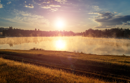 landscape with rut road on sunset sky. with sunbeam background. unusual amazing sunset. creative imageの写真素材