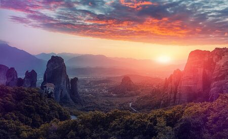 Fantastic Landscape with monasteries and rock formations in Meteora during sunset, Greece. Mysterious Sunny Morning with colorful sky. Awesome Nature Landscape. Popular travel locationsの写真素材