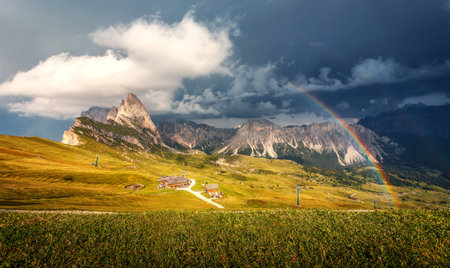 The rainbow over the seceda ridge, idyllic mountain scenery in the Dolomites Alps with Majestic Peaks, Overcast sky and Rainbow. Odle mountain range, Val Gardena in Dolomites. Italy. Amazing Natureの写真素材