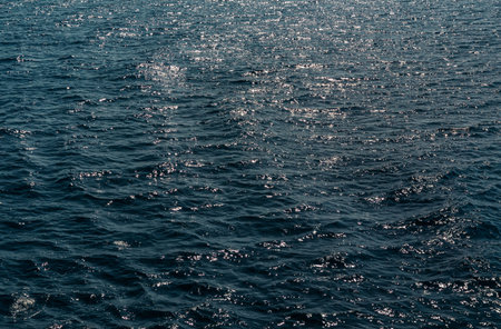 Background of transparent blue sea water top view. Water ripples and pattern on ocean surface with...