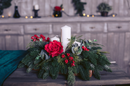 Decorative Christmas tree branches with candle and rosesの写真素材