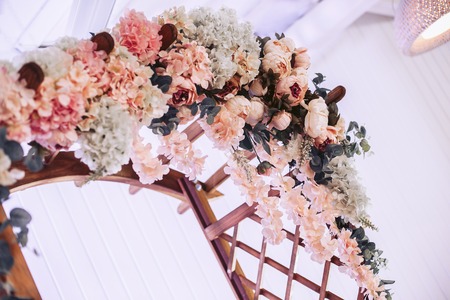 A voluminous wedding arch made of wood in flowers and plantsの写真素材