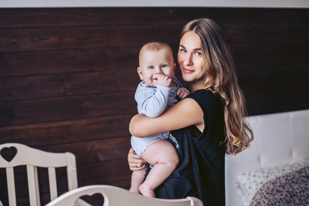Beautiful mother with a little baby pose at homeの写真素材