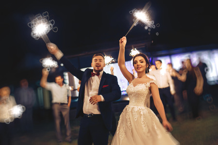 The bride and groom waving Bengal lightsの写真素材