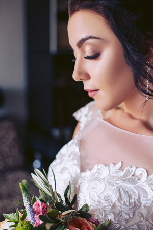 The bride closed her eyes. Stand with a bouquet of flowersの写真素材