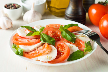 Close-up photo of caprese salad with ripe tomatoes, basil, buffalo mozzarella cheese. Italian and Mediterranean food concept. Fresh and healthy organic meal. Starter and antipasti.の写真素材