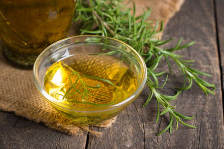 Rosemary oil on wooden background. Natural food concept.の写真素材