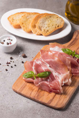 Closeup of thin slices of prosciutto with mixed olivesの写真素材
