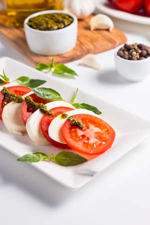 Close-up photo of caprese salad with ripe tomatoes, basil, buffalo mozzarella cheese. Italian and Mediterranean food concept. Fresh and healthy organic meal. Starter and antipasti.の写真素材