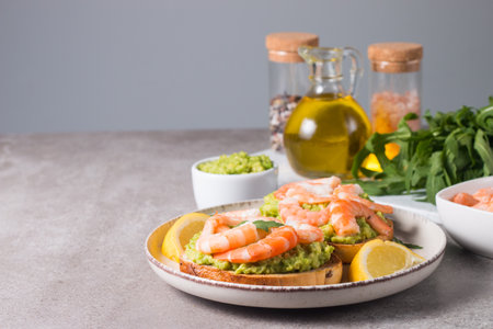 Avocado toast with shrimps, arugula and lemonの写真素材