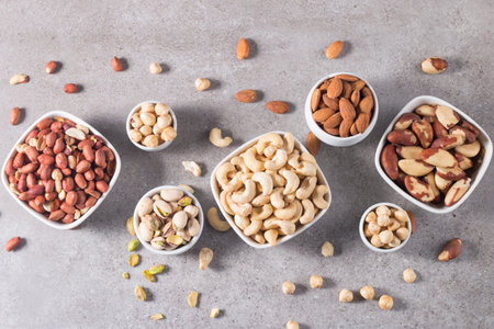 Mix of nuts in bowls on gray background. Top view, copy spaceの写真素材