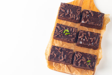 chocolate brownies on wood board with mint leaves on white backgroundの写真素材