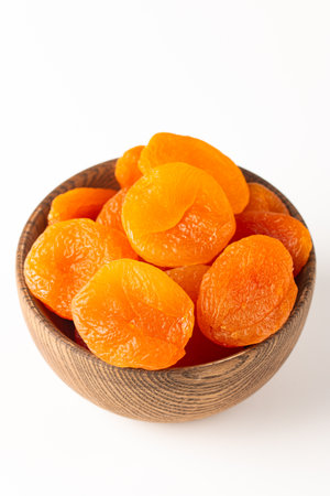 Dried apricots in wooden bowl isolated on white background.の写真素材