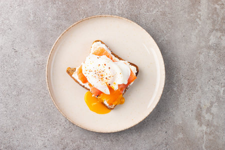 Toast with poached egg and salmon on plate, top viewの写真素材