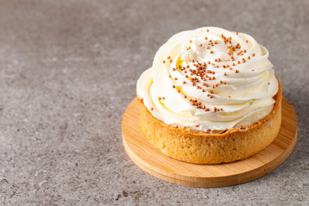 Lemon tart with whipped cream on a wooden board. Copy space.の写真素材