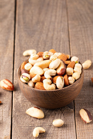 Mix of nuts in bowl on wooden background. Nuts mix.