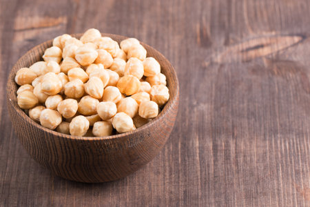 Chickpeas in a wooden bowl on a wooden background.の写真素材