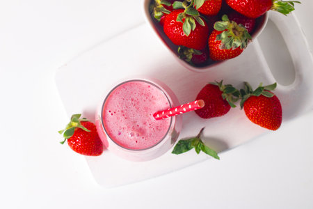 Strawberry milkshake with fresh berries on a white backgroundの写真素材