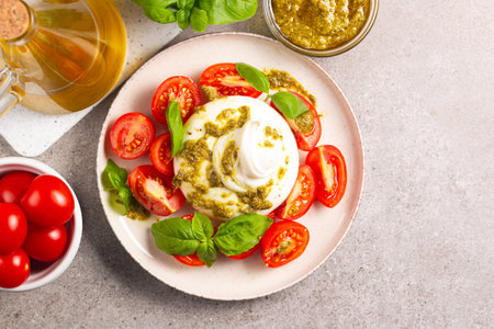 Traditional italian caprese salad with mozzarella cheese, cherry tomatoes and basil. Top view