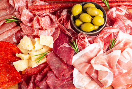 Assortment of meat products including prosciutto crudo or jamon, parmesan cheese and olives