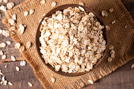 oat flakes in a bowl on a wooden background. oat flakes