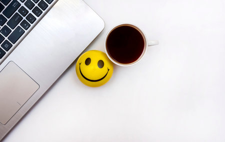 computer work space with coffee and yellow toy ballの写真素材
