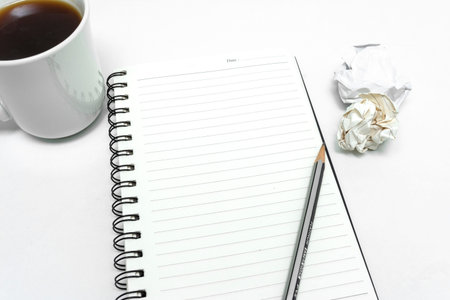 Spiral Notebook with a pen , glass and a cup of coffee on a white background
