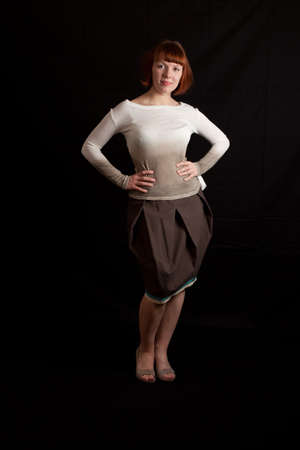 a young adult woman wearing sweater and skirt posingの写真素材