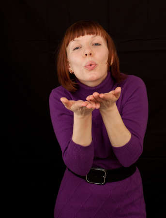 a young adult woman wearing a purple dress sending kissesの写真素材