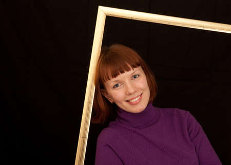 a closeup of a young adult woman leaning in a picture frameの写真素材