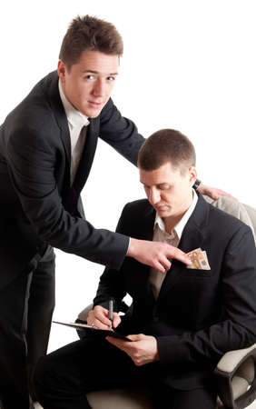 a young businessmen signing a contract while receiving moneyの写真素材