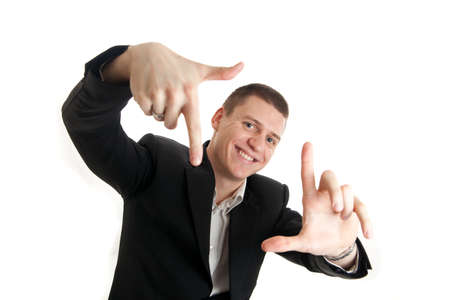 a young businessman framing his face with his handsの写真素材