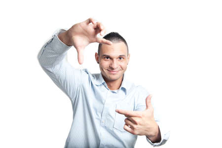 a young man wearing a shirt framing his face with his handsの写真素材
