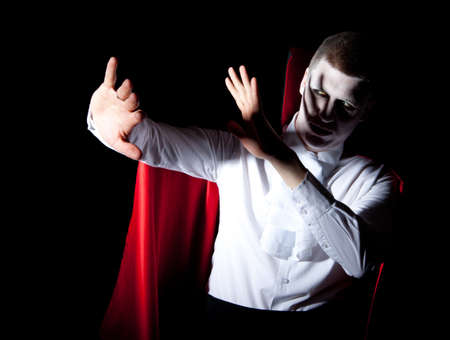 a young male vampire protecting himself from bright lightの写真素材