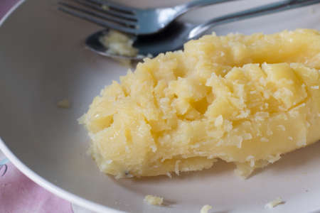 Baked potato and spread with butterの写真素材