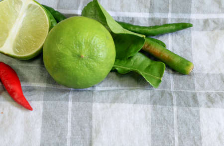 the vegetable background Lemon leaf,Chili,Lime on the handkerchief , combination to make spice foodの写真素材