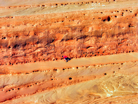 Late Afternoon sunlight on sandstone and boy climbing, Arches National Park, Utah by Delicate Arch,...
