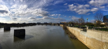 Downtown City Skyline Indianapolis Indiana White River in spring with blooming trees and vegetation, pedestrian bridges and ruins.の写真素材